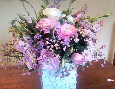 A vase filled with pink flowers is on a table