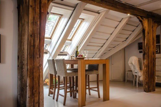 A dining room with a table and chairs in the attic.