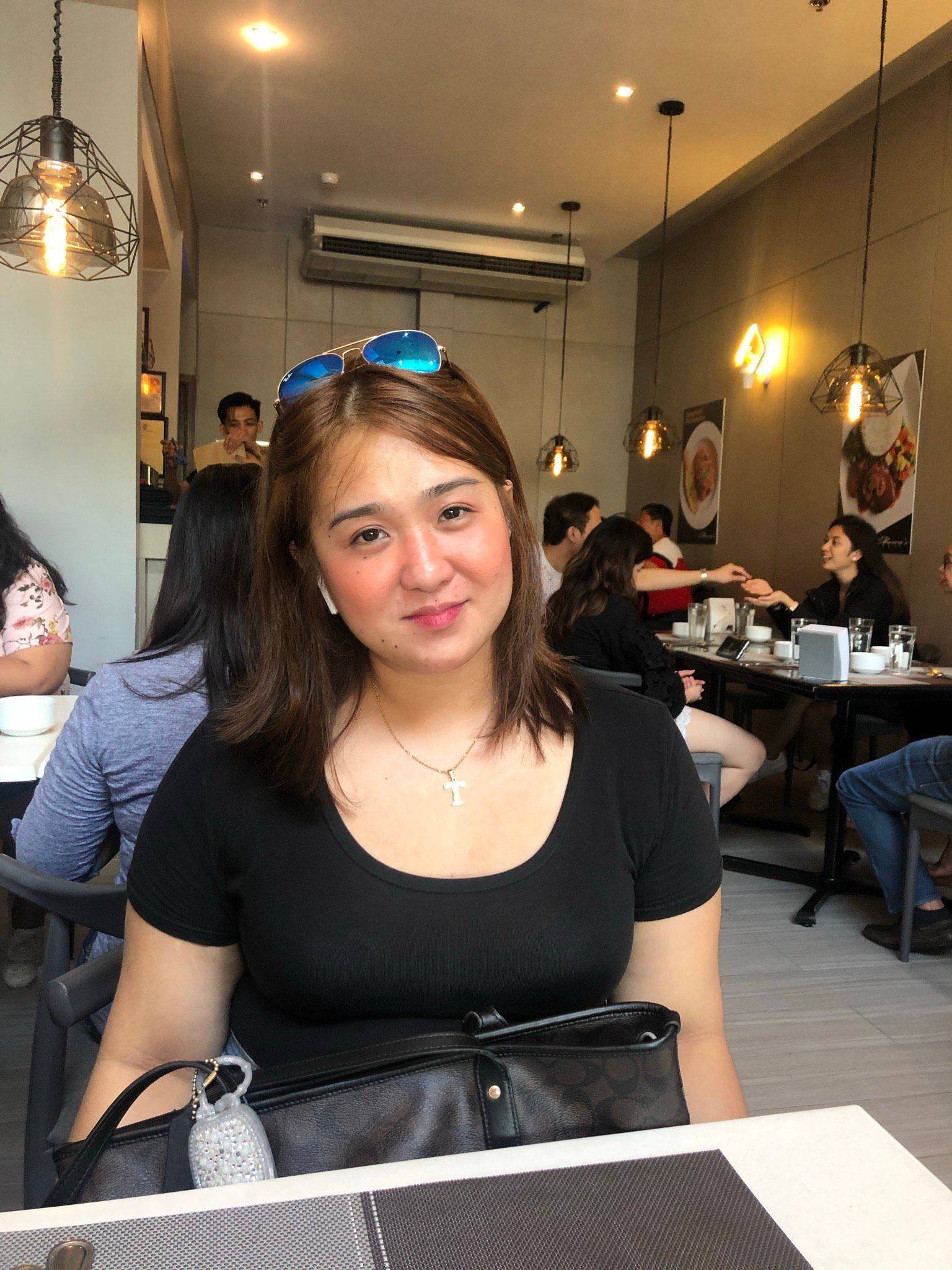A woman is sitting at a table in a restaurant.