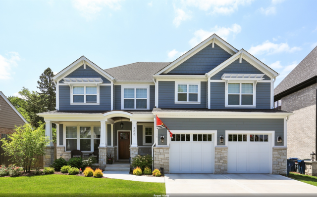 A large house with blue siding and white garage doors