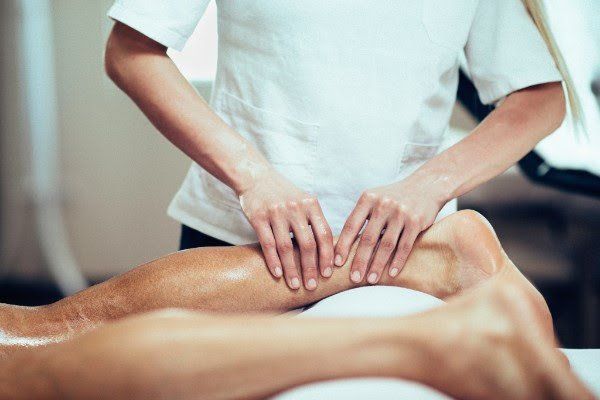 A woman is giving a man a leg massage in a spa.