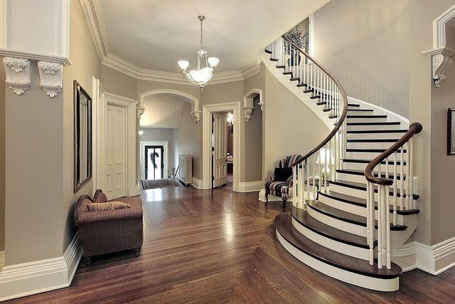 A large hallway with a curved staircase in the middle of it.