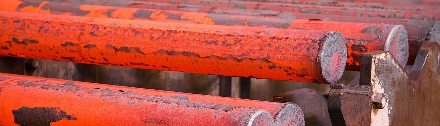 A bunch of rusty metal pipes sitting on top of each other on a table.