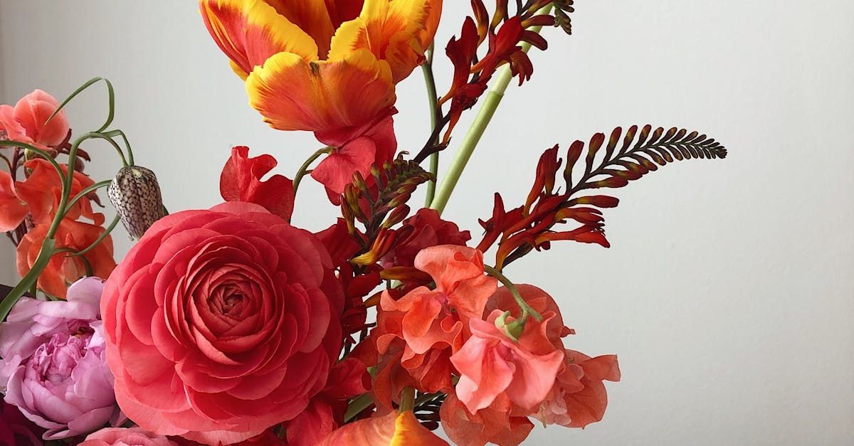 A close up of a bouquet of flowers in a vase on a table.