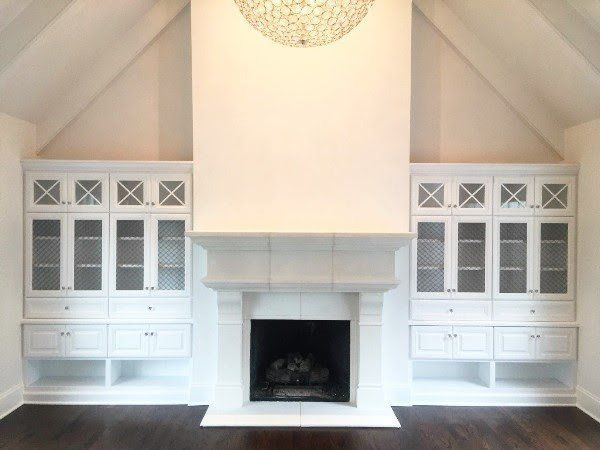 A living room with white cabinets and a fireplace