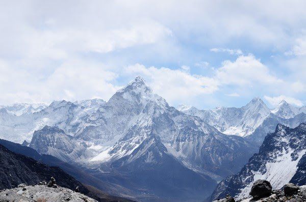 A view of a snowy mountain range with a blue sky in the background.