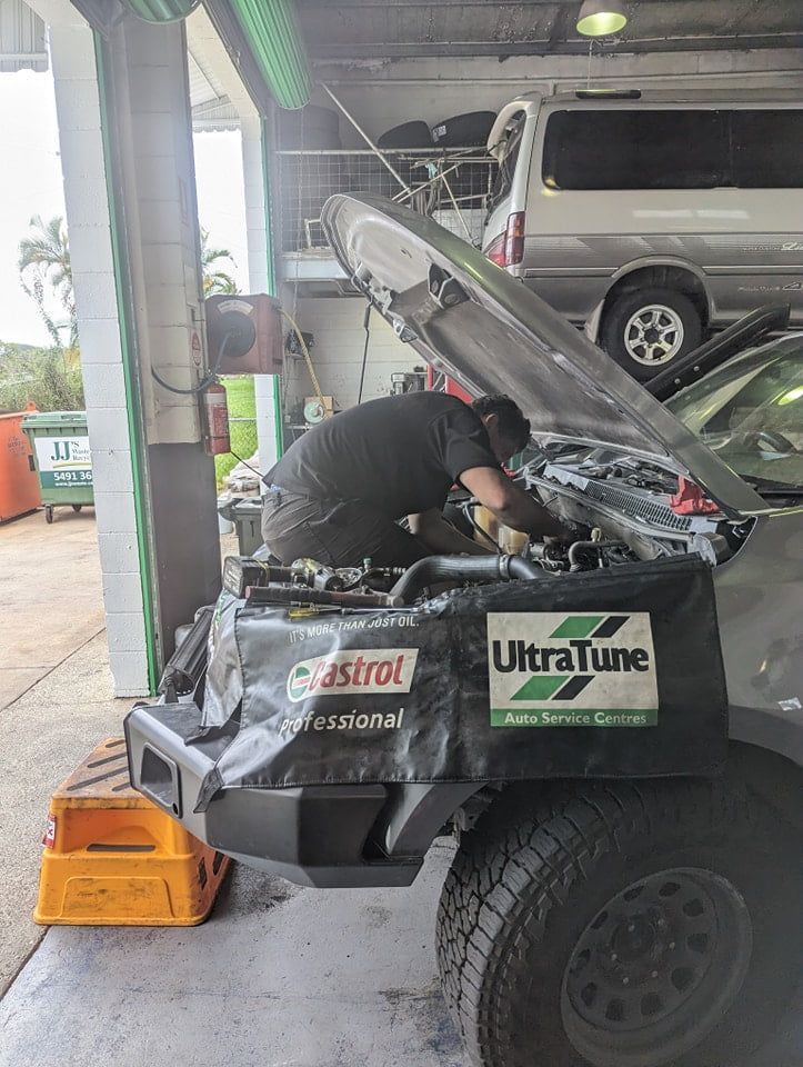 A Man is Working on the Engine of a Car in a Garage — Ultra Tune Nambour In Nambour, QLD