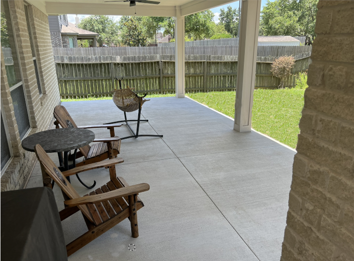 A patio with chairs , a table and a ceiling fan.
