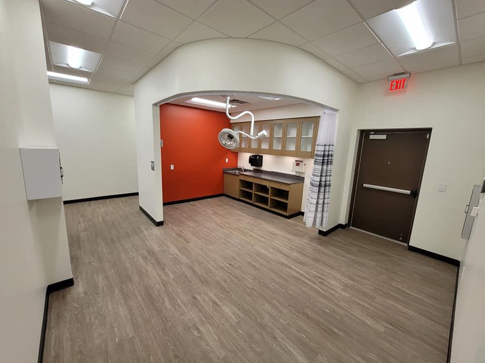 A large empty room with a surgical light hanging from the ceiling.