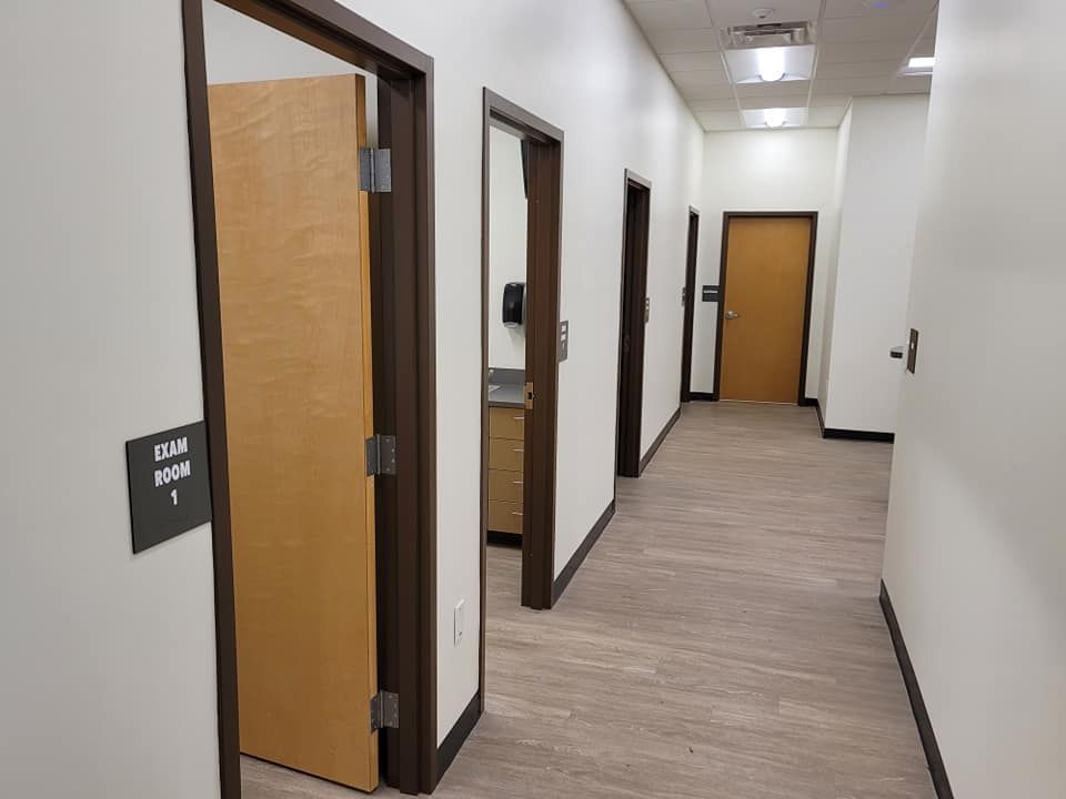 A long hallway with wooden doors and a sign on the wall.