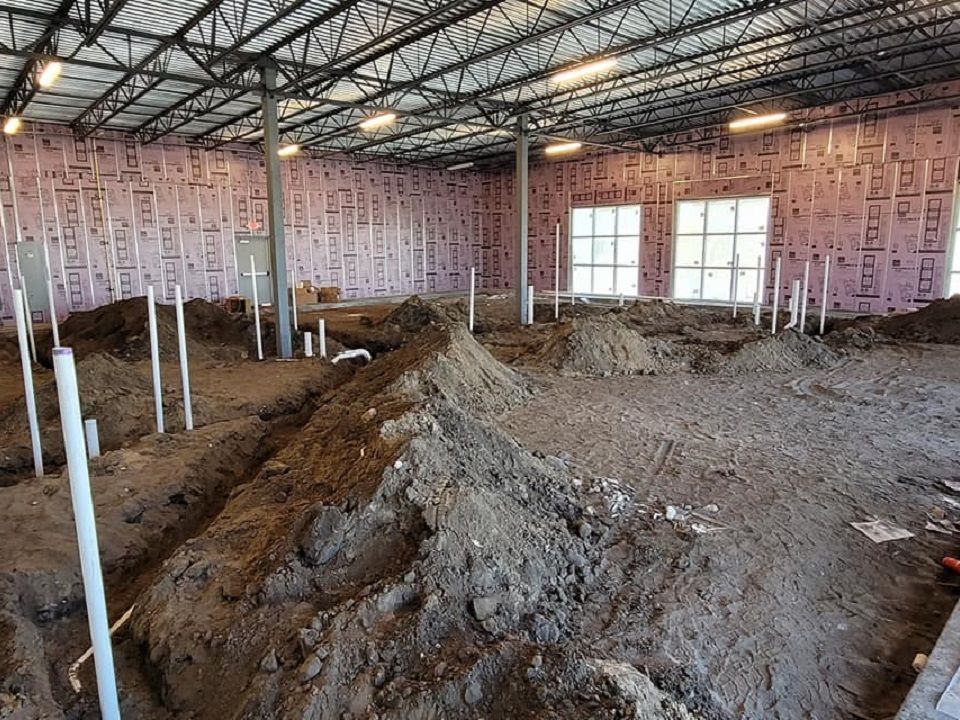 A large room with a lot of dirt and pipes in it.