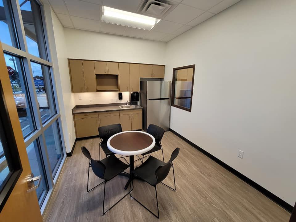 A kitchen with a table and chairs and a refrigerator.