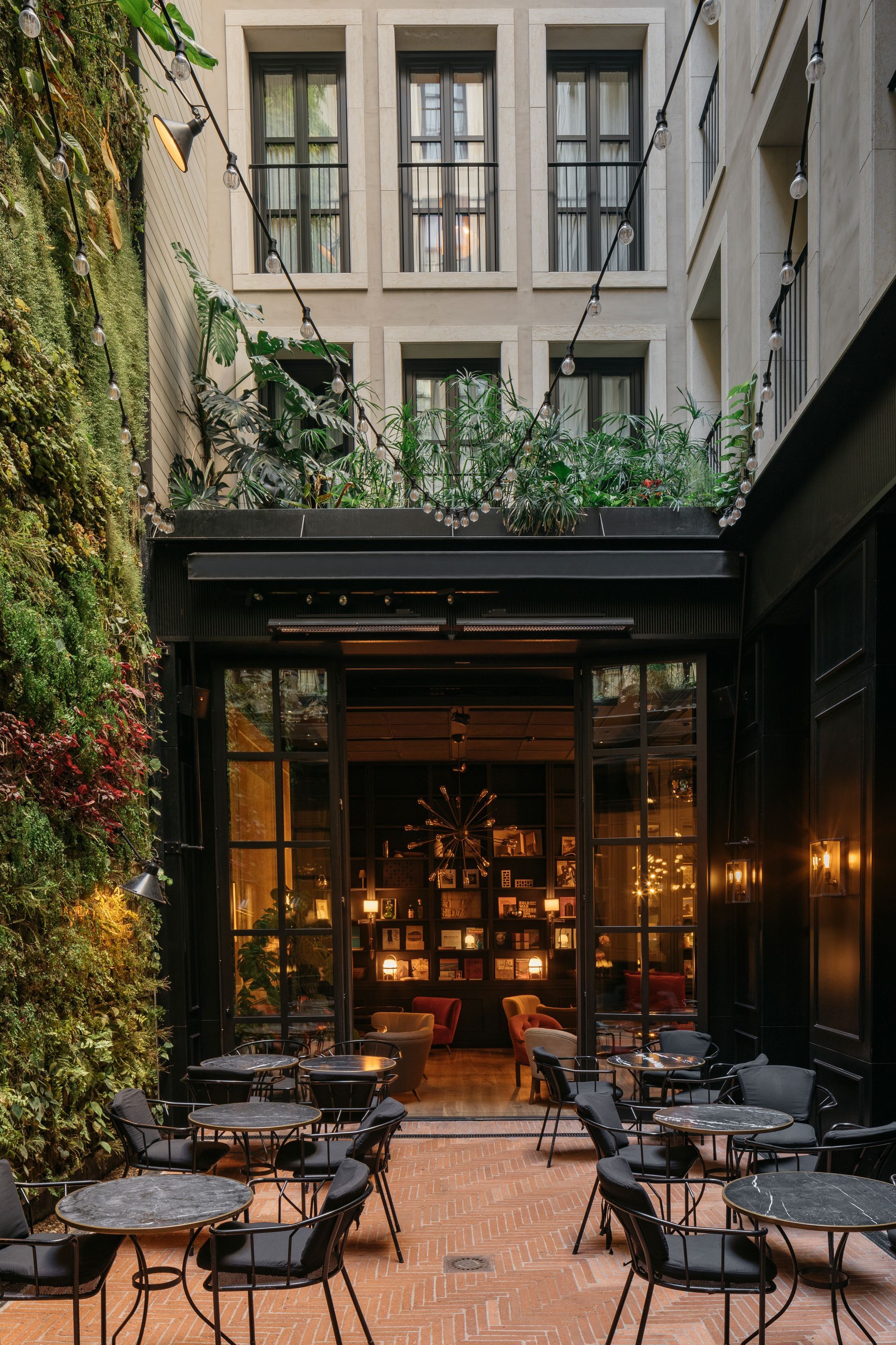 A restaurant with tables and chairs in front of a building at Wittmore Hotel in Barcelona, Spain.