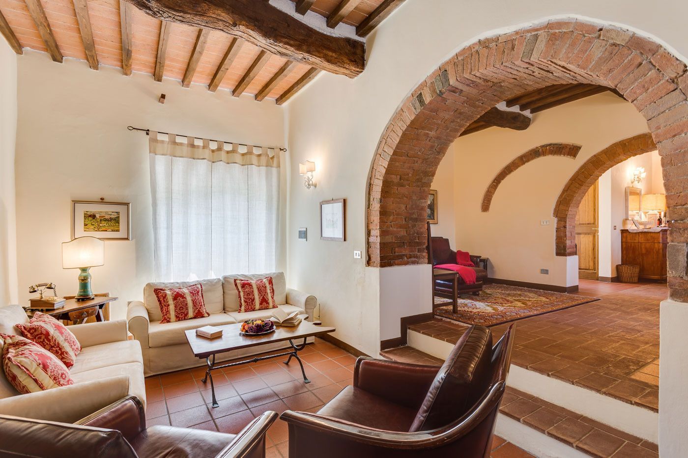 A living room with a couch, chairs, and stairs at villa in Tuscany.