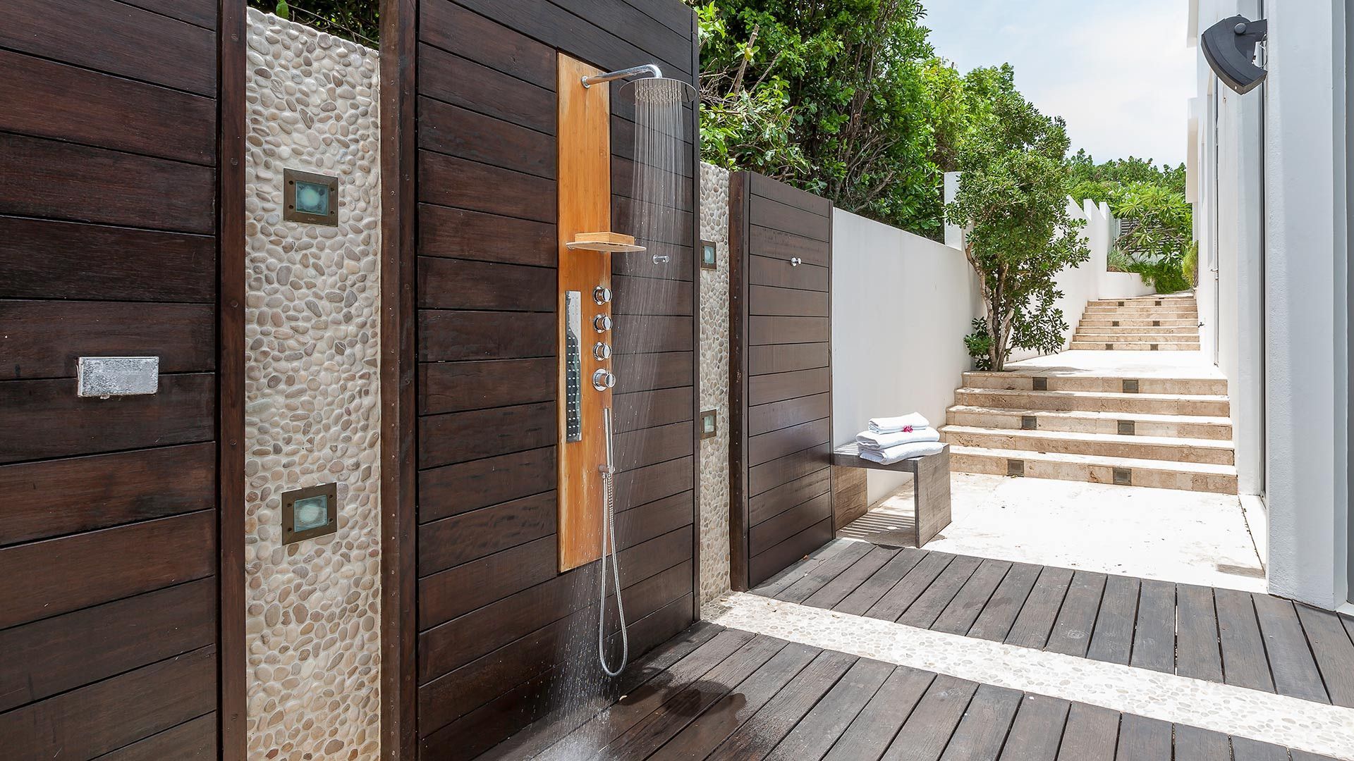 A wooden fence with a shower in the middle of it at villa in Antigua.