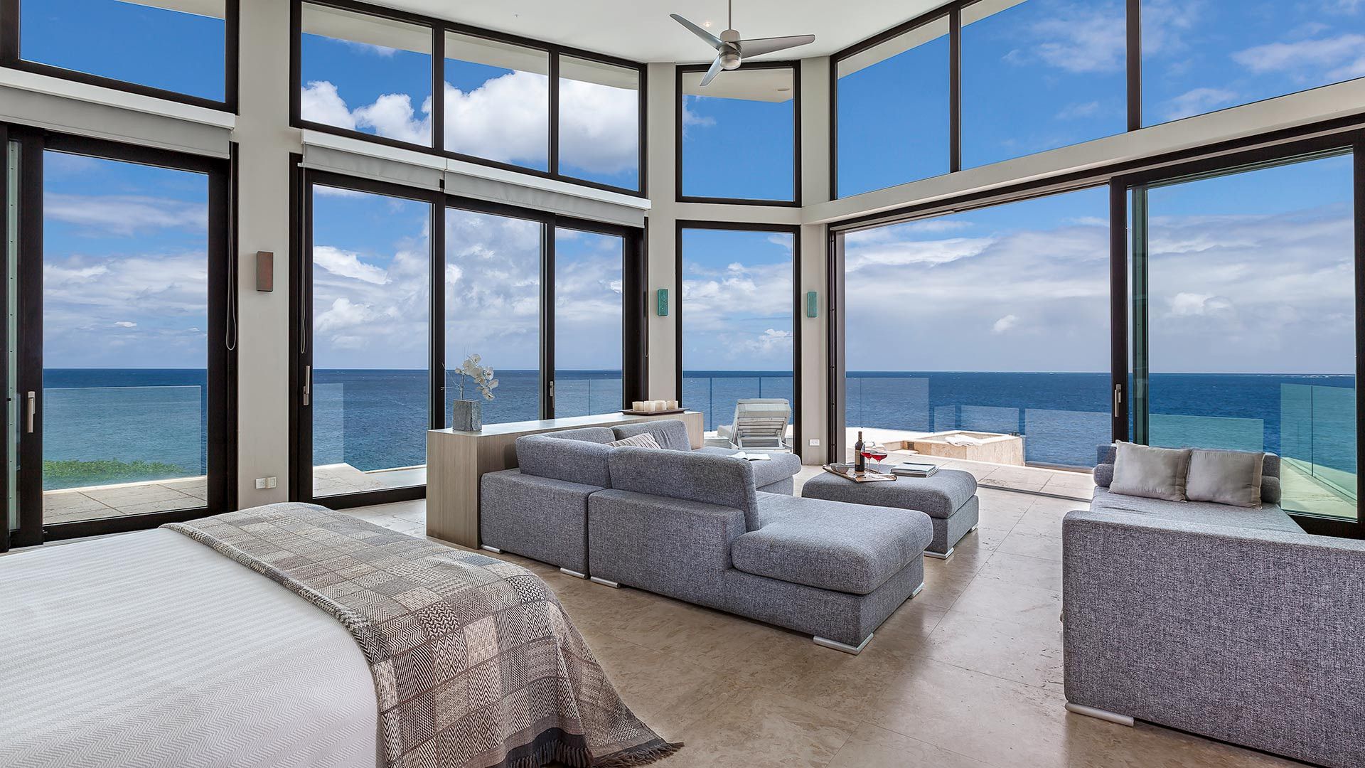 A bedroom with a couch and a bed with a view of the ocean at villa in Antigua.