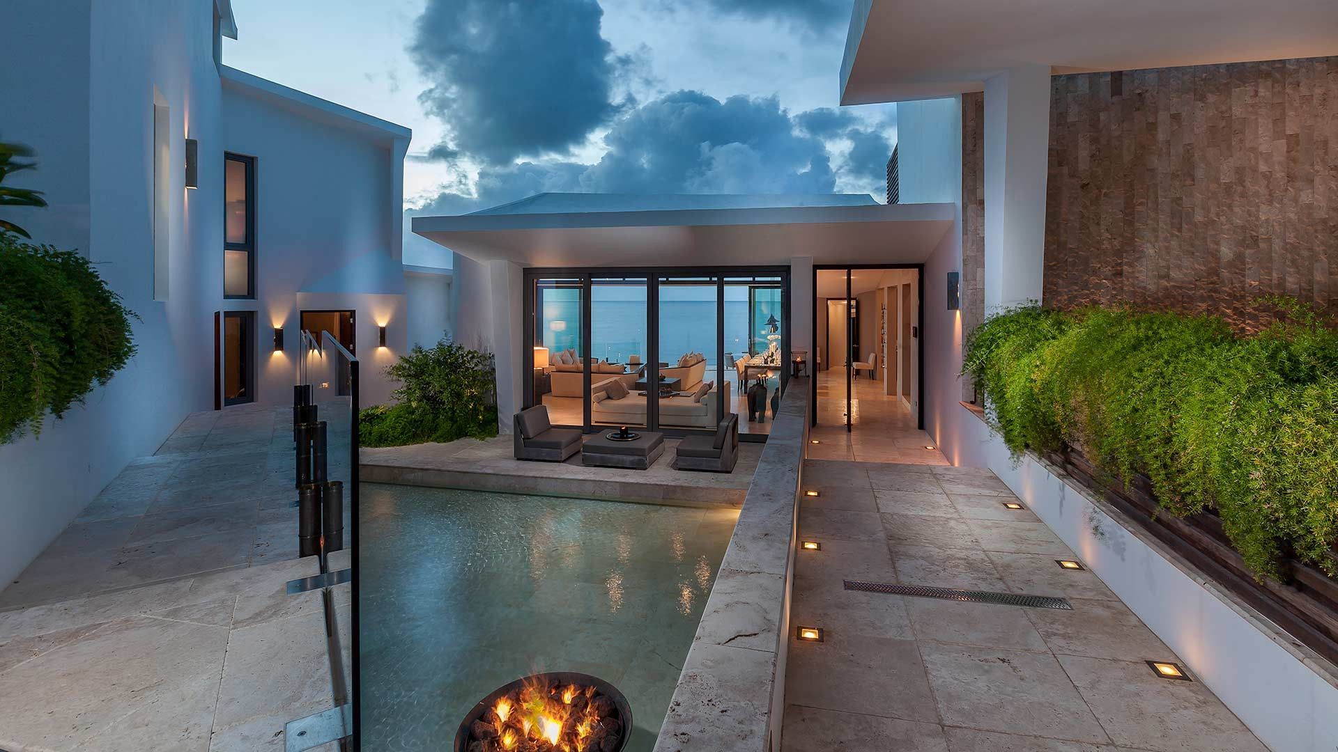 A large villa with a swimming pool and a fire pit in front of it in Antigua.