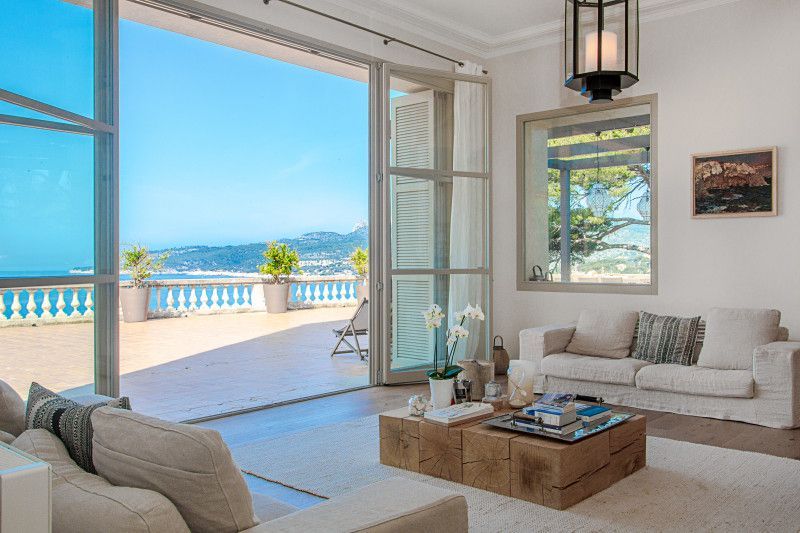 A living room with two couches, a coffee table, and a view of the ocean at villa in Cote D'Azur, France.