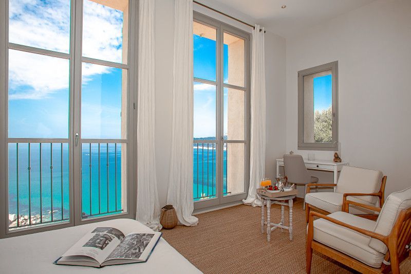 A bedroom with a large window overlooking the ocean at villa in Cote D'Azur, France.