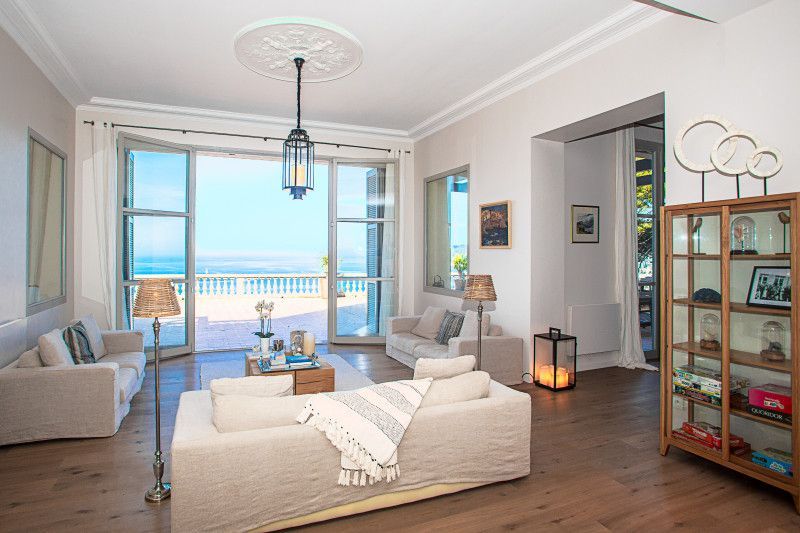 A living room with a lot of furniture and a view of the ocean at villa in Cote D'Azur, France.