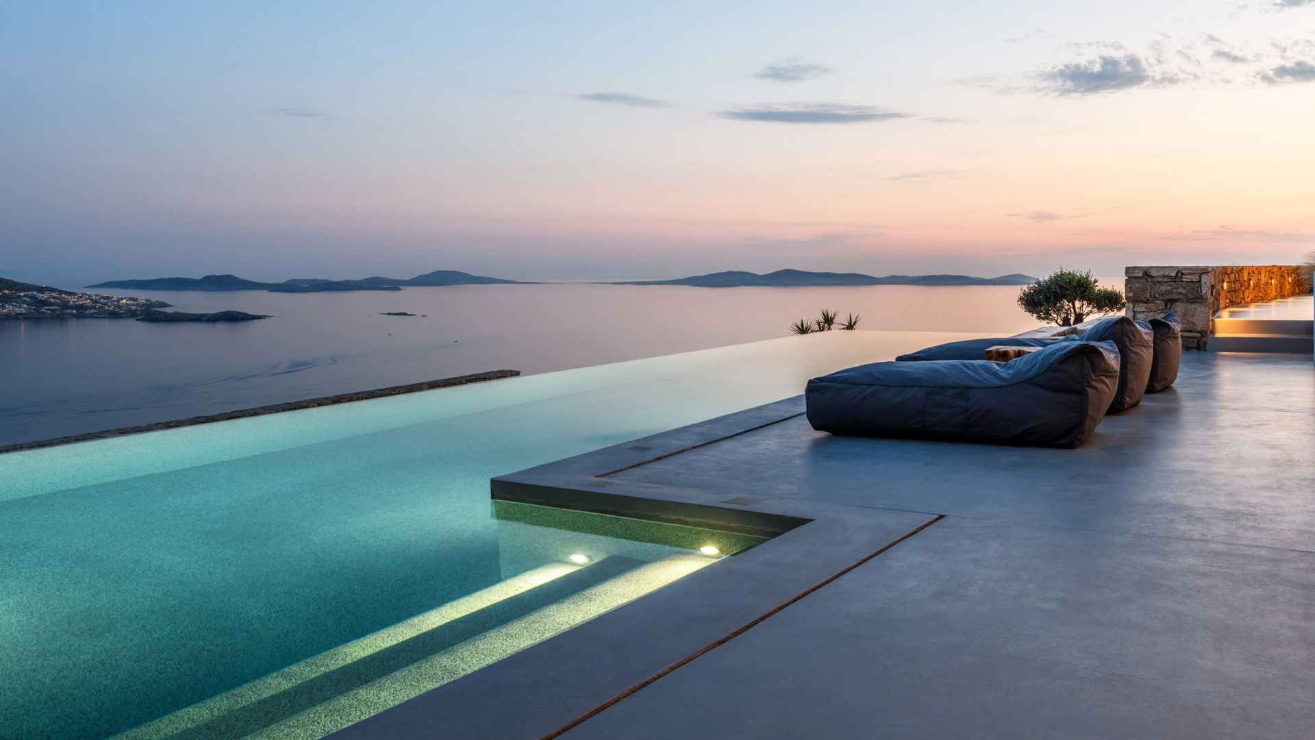 There is a swimming pool with a view of the ocean at villa in Mykonos, Greece.