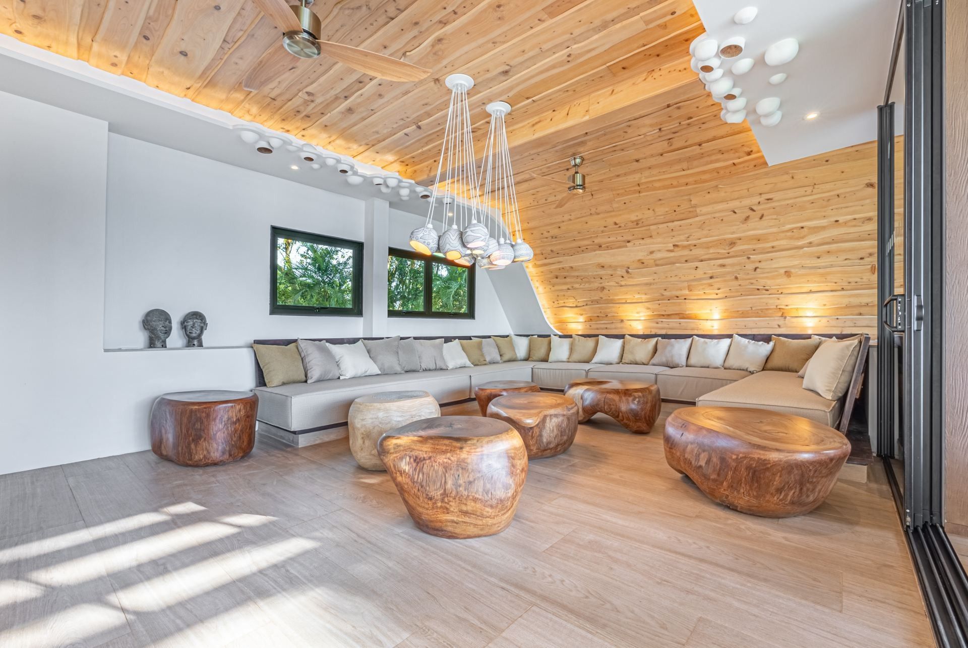 A living room with a large sectional couch and wooden tables at villa in Costa Rica.