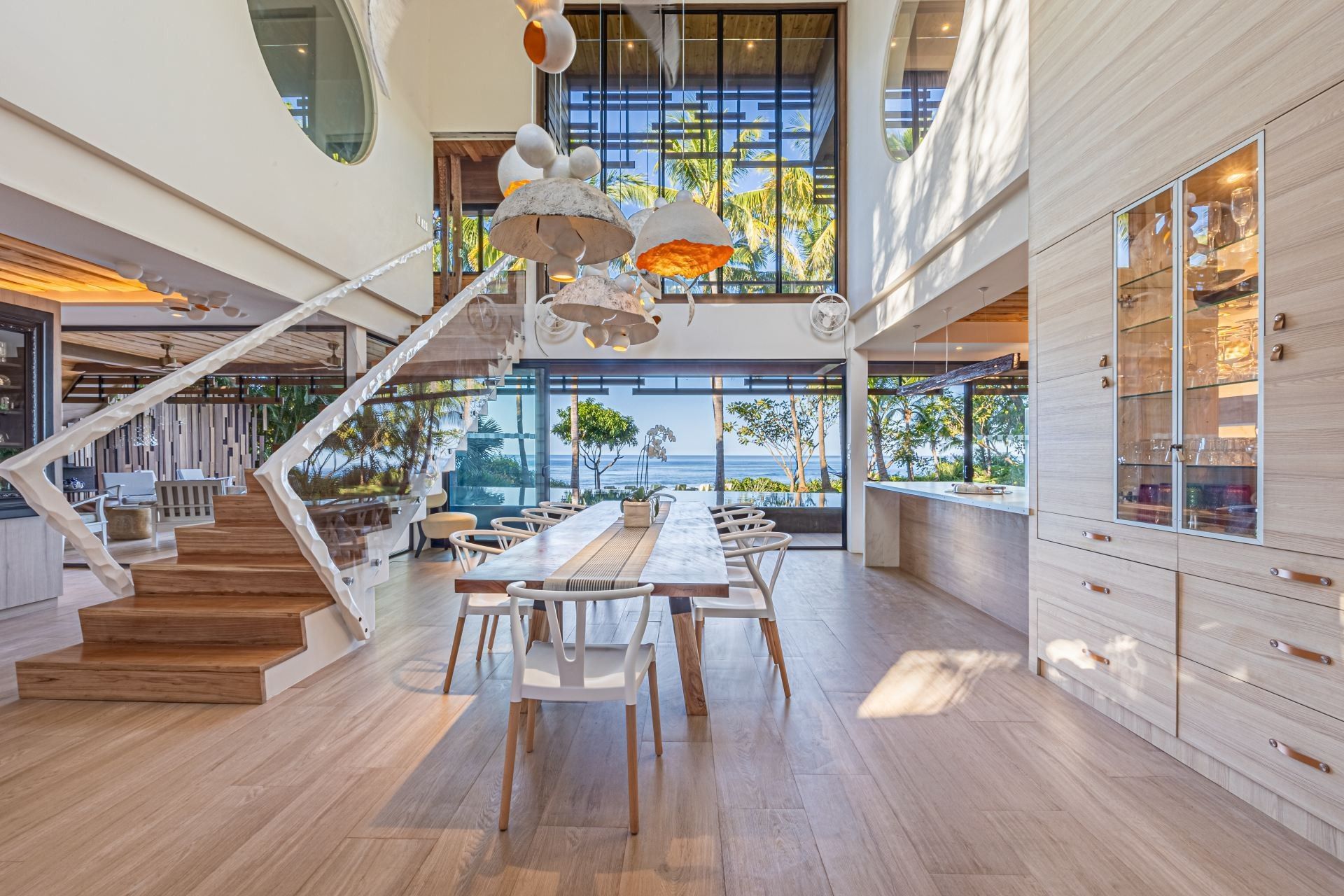 A large dining room with a long table and chairs and stairs leading up to it at villa in Costa Rica.