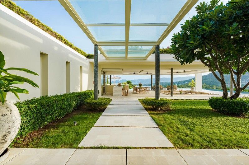 A walkway leading to a large villa with a glass roof in Koh Samui, Thailand.