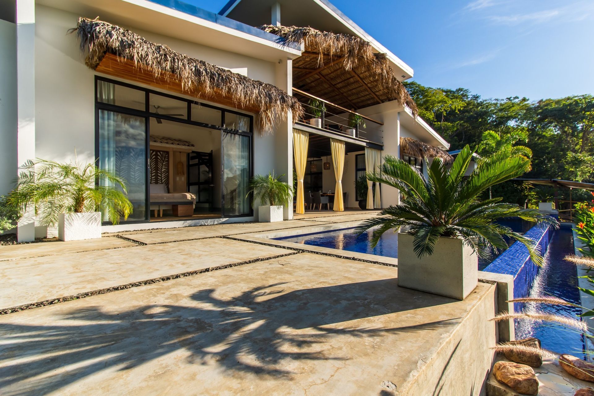 A large white villa with a swimming pool in front of it in Costa Rica.