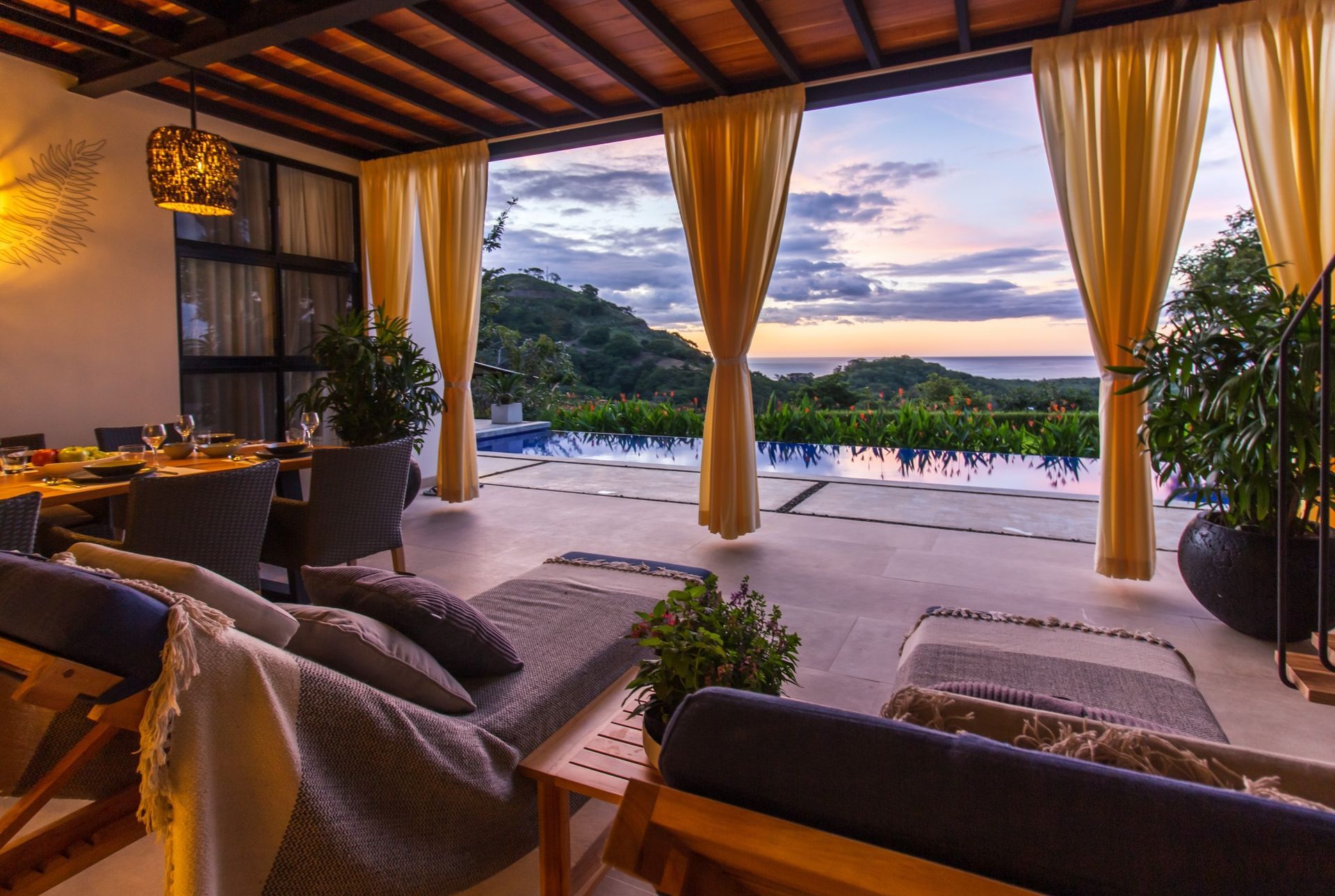 A living room with a view of the ocean and a swimming pool at villa in Costa Rica.