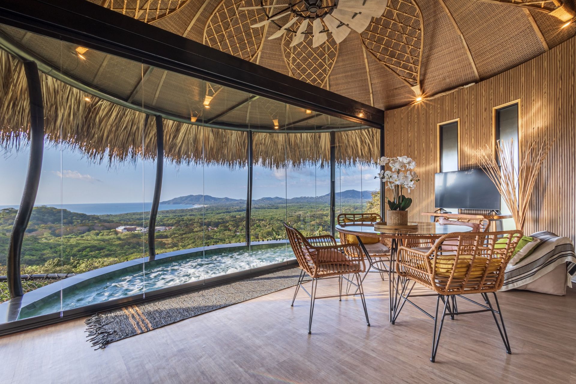 A living room with a table and chairs and a view of the ocean at villa in Costa Rica.