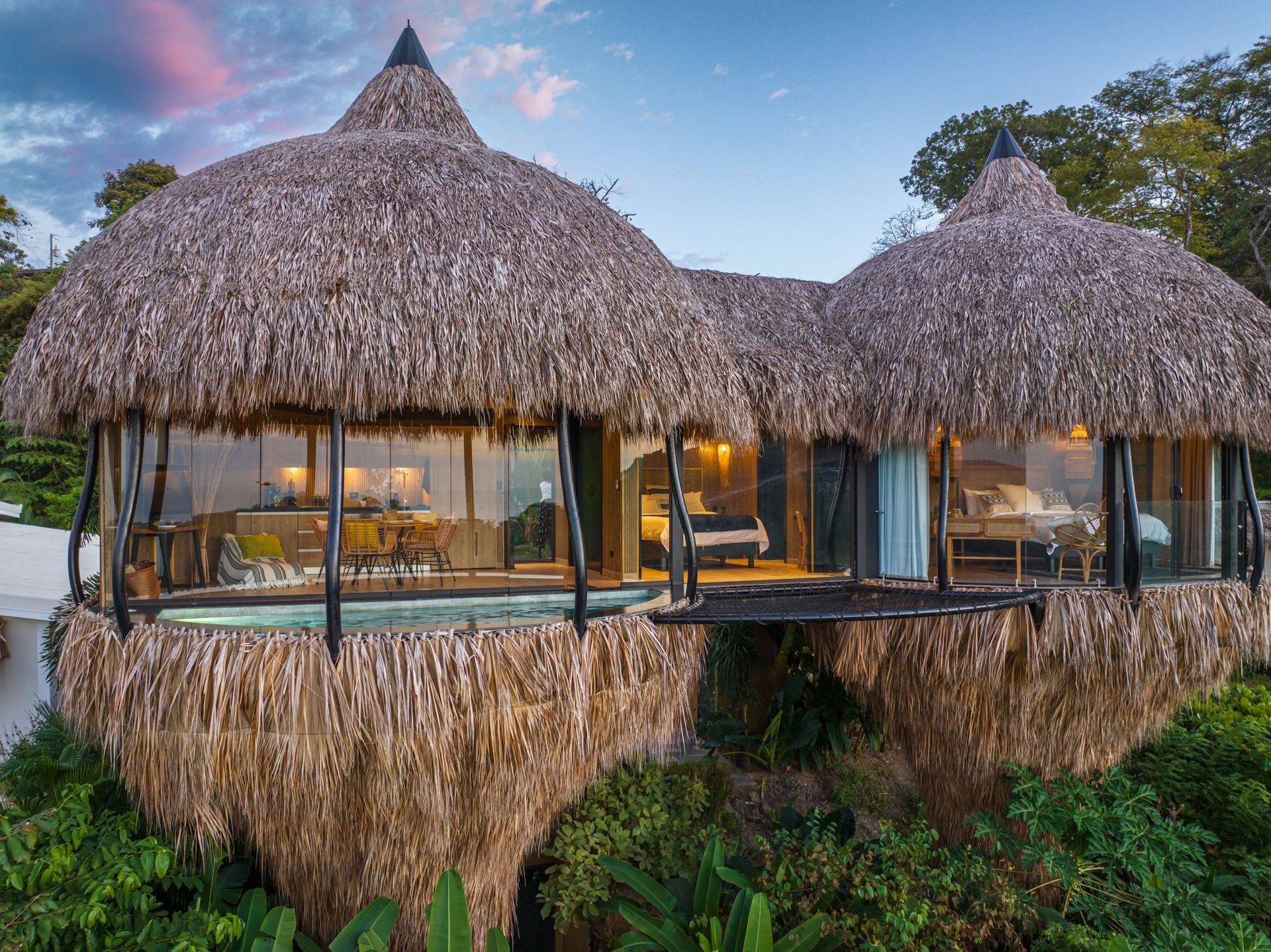 A villa with a thatched roof is surrounded by trees in Costa Rica.