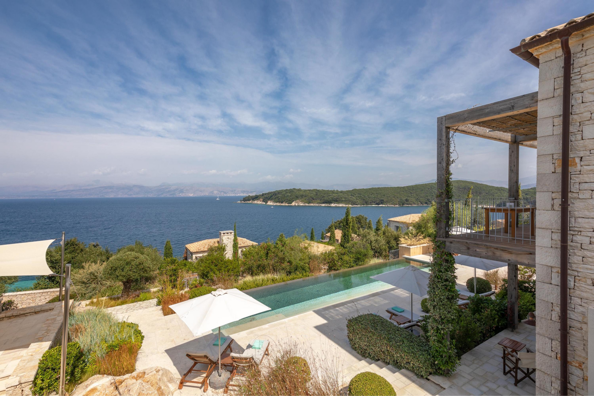 A large villa with a swimming pool and a view of the ocean in Corfu, Greece.