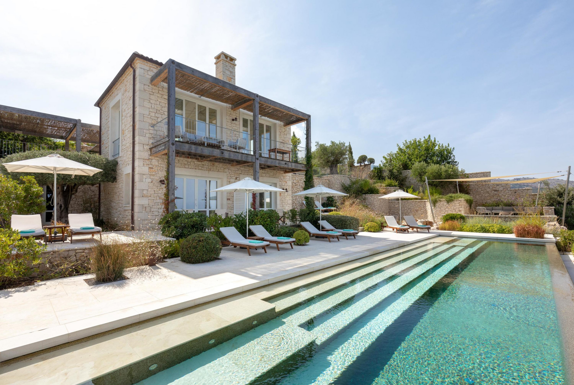 A large villa with a swimming pool in front of it in Corfu, Greece.