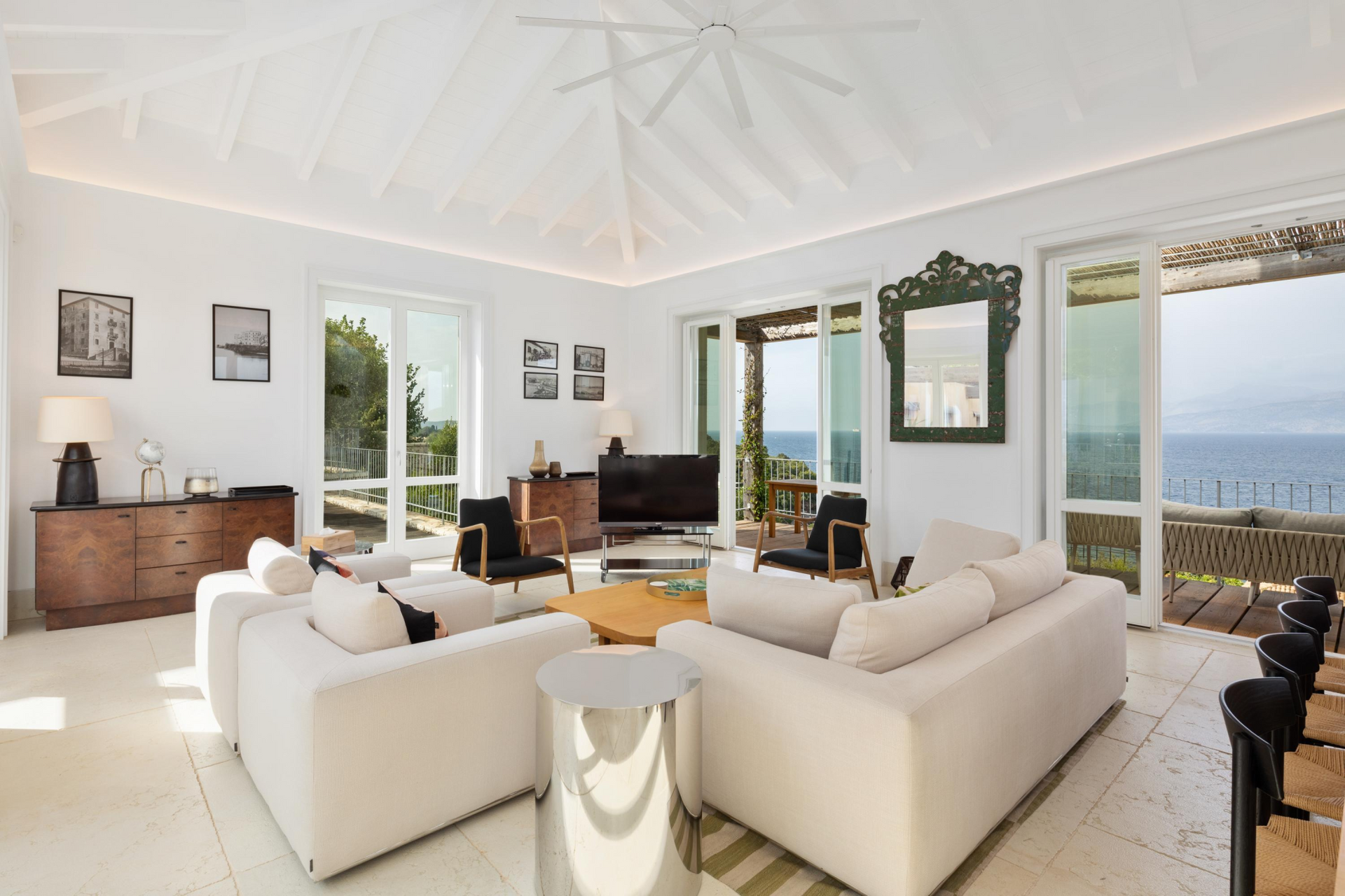 A living room with white furniture and a flat screen tv at villa in Corfu, Greece.