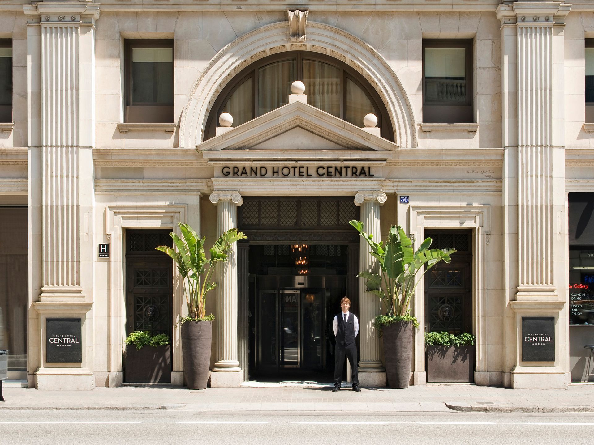 A man stands in front of the grand hotel central at Grand Hotel Central in Barcelona, Spain.