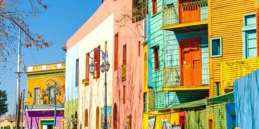 A row of colorful buildings in a city on a sunny day in Buenos Aires.