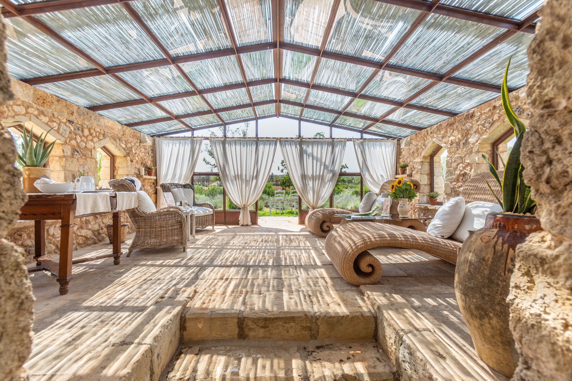 A large room with a glass roof and a lot of furniture at Naturalis Bio Resort & Spa in Puglia, Italy.