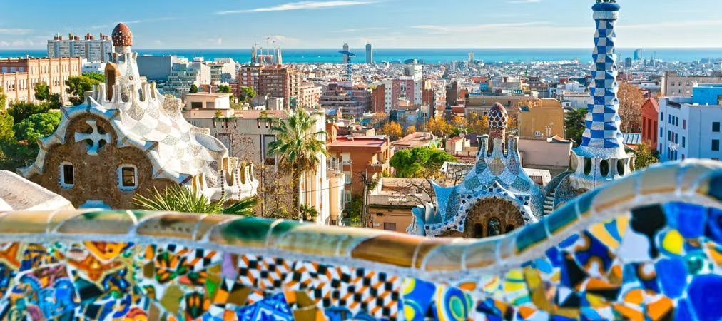 An aerial view of a city with Park Güell in the foreground in Barcelona.