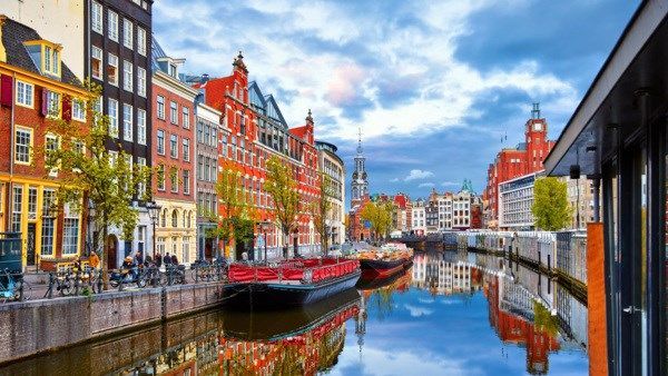 A boat is floating on a canal in amsterdam.