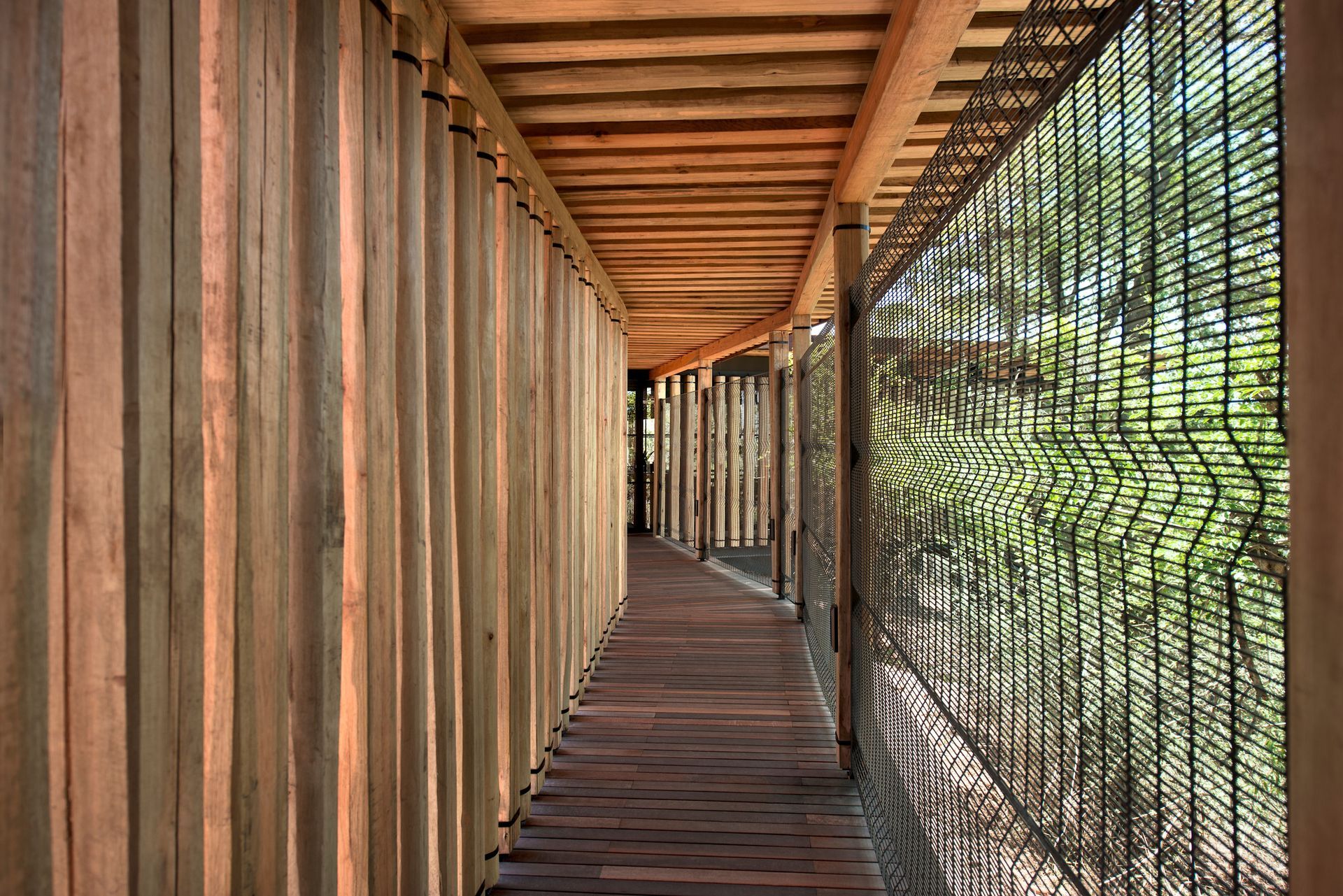 A long wooden walkway with a metal fence in the background at a camp in Africa.