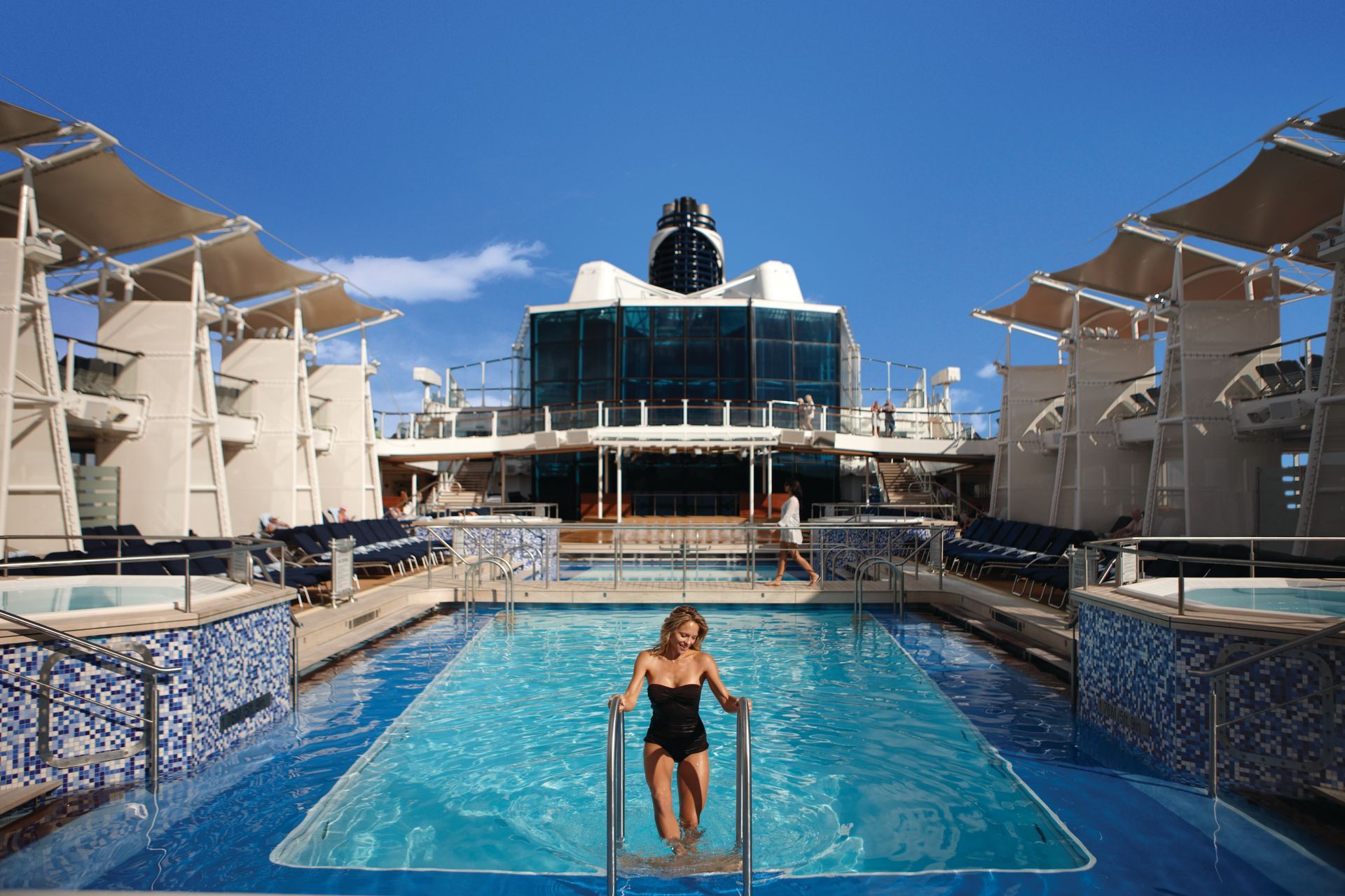A woman is getting out of a swimming pool on the Celebrity Equinox cruise ship.