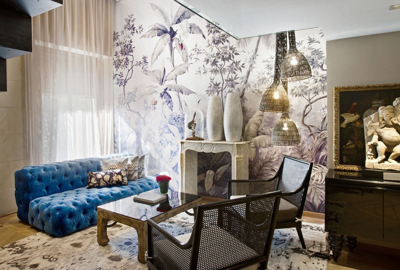 A living room with a blue couch and chairs at Claris Hotel & Spa in Barcelona, Spain.