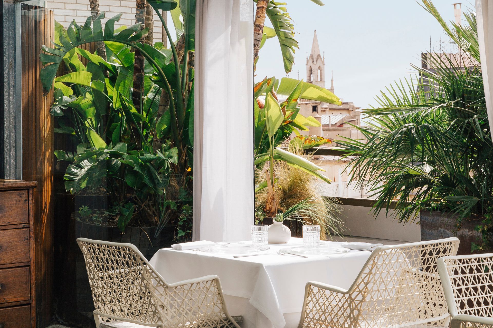 A table and chairs on a patio with a view of Barcelona, Spain at Claris Hotel & Spa.