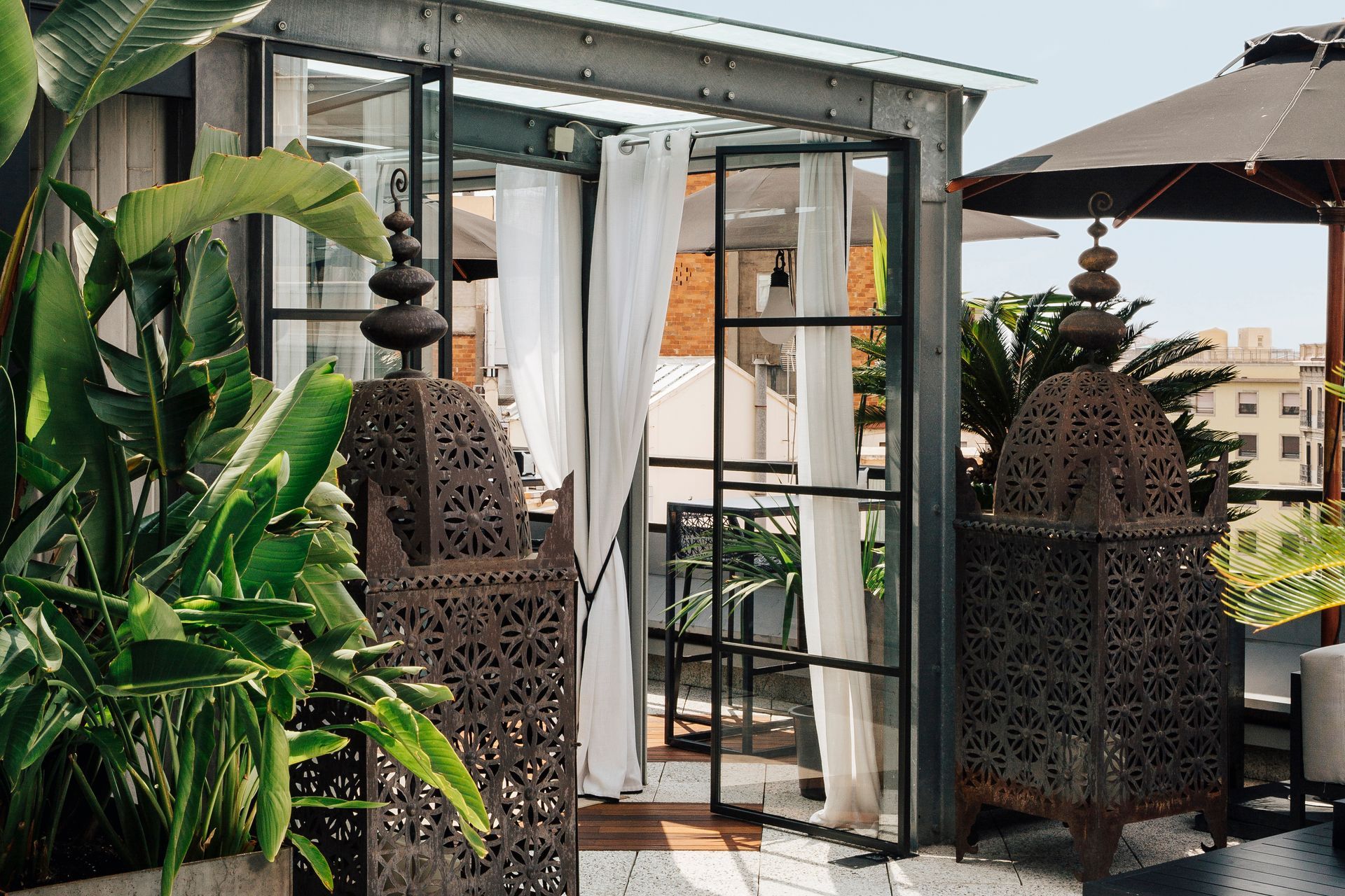 A patio with a glass door and a lantern in front of it at Claris Hotel & Spa in Barcelona, Spain.