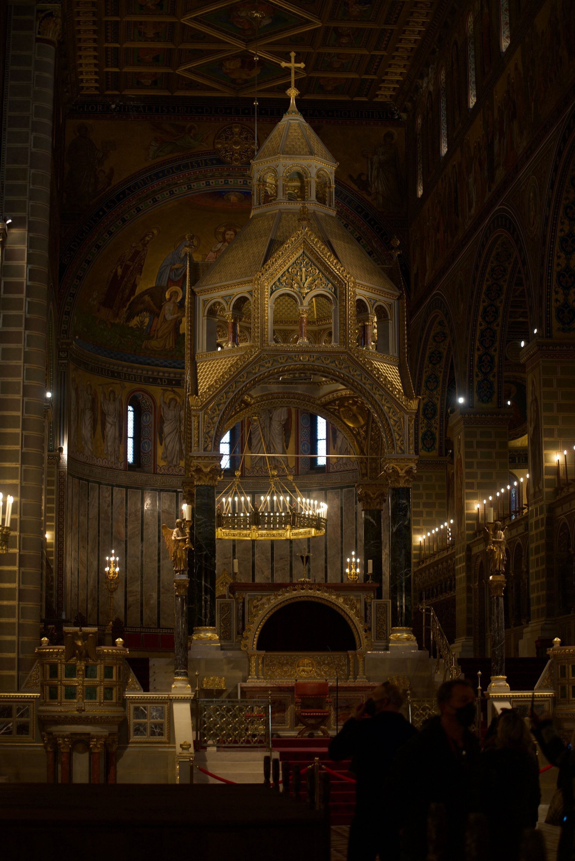 Golden altar inside a cathedral with intricate carvings, under a domed ceiling.