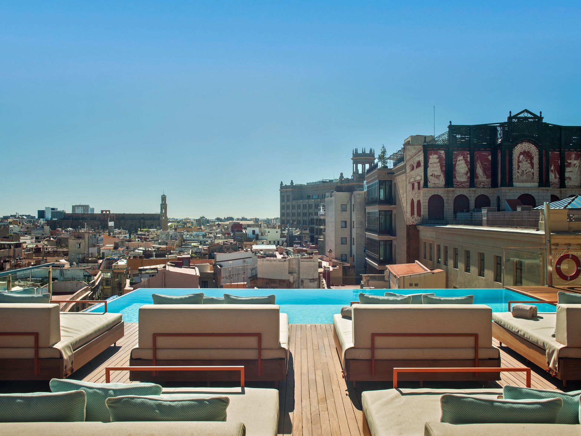 A swimming pool with a view of a city in the background at Grand Hotel Central in Barcelona, Spain.