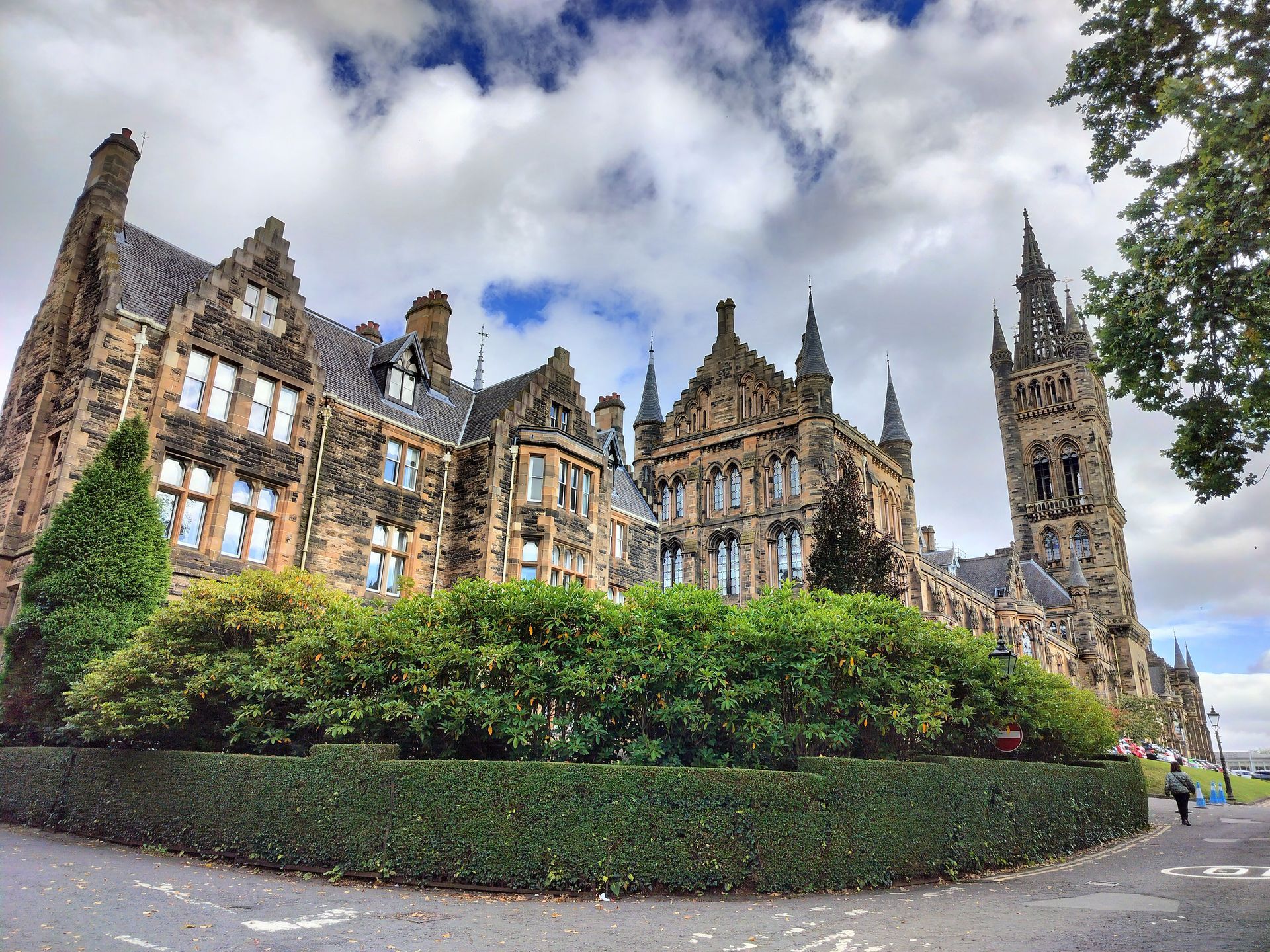 Stone gothic university building under cloudy sky.