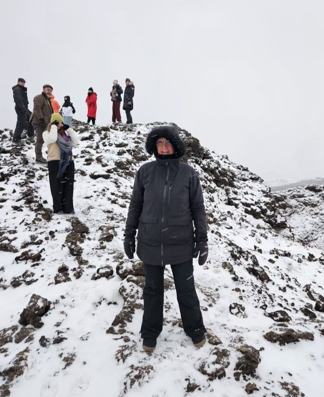 A person in a blue jacket is skiing down a snowy hill