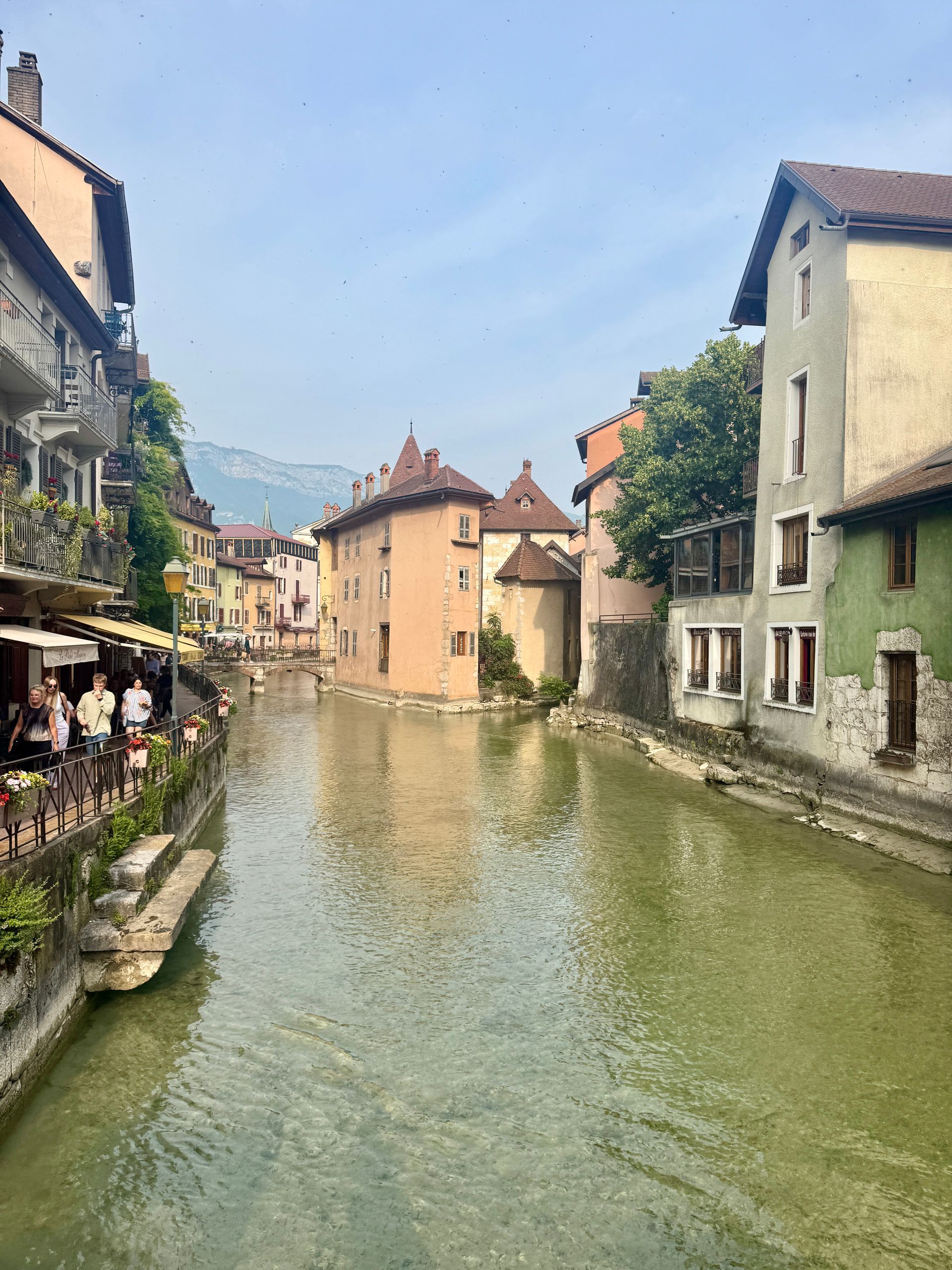 A canal runs through Annecy, France, surrounded by buildings.